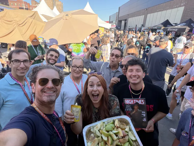 Jordan Isenstadt taking a group selfie with friends, a tray of apple slices and a copy of High Times at Revelry