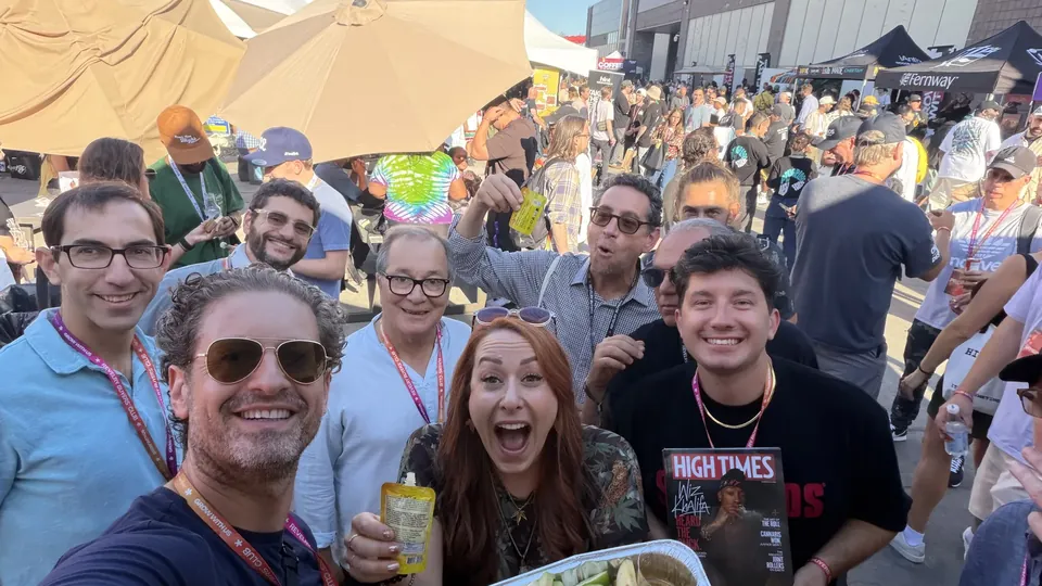 Jordan Isenstadt taking a group selfie with friends and a tray of apple slices at Revelry