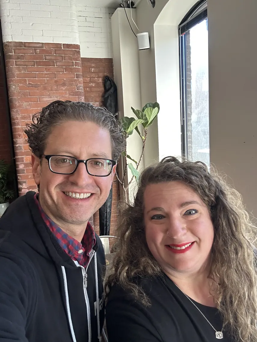 Jordan Isenstadt with a smiling guest by the window