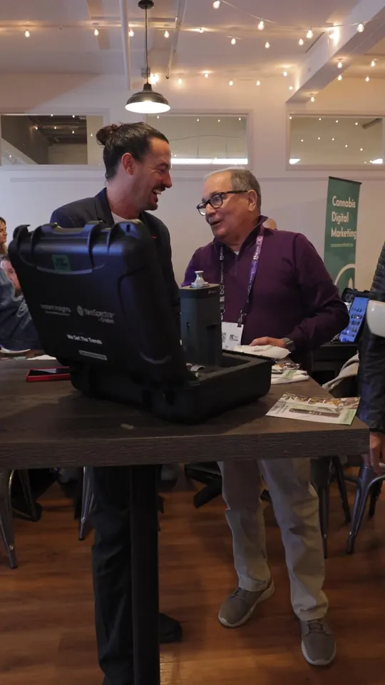 Two attendees talking at an exhibitor table