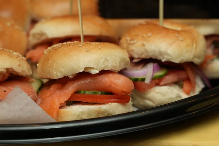 Platter of mini bagel sandwiches with lox, tomato and cucumber