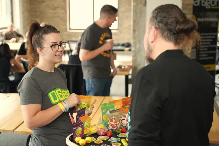 Exhibitor showing products at a brightly colored table