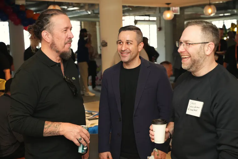 Three attendees laughing mid-conversation