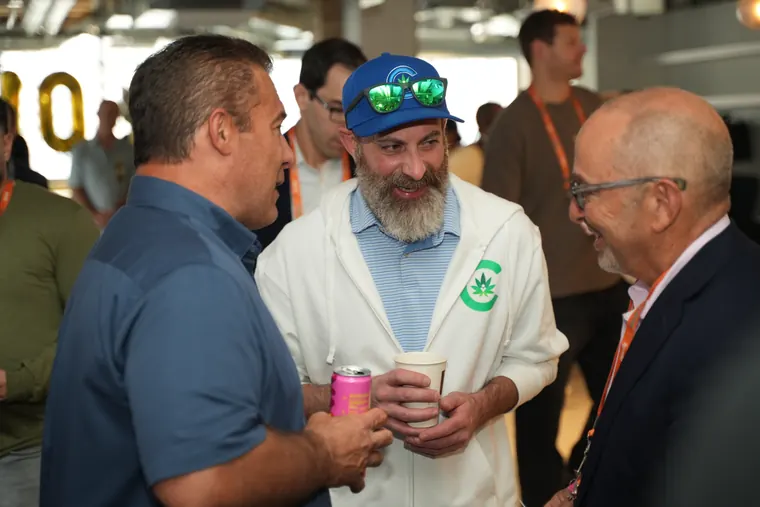 Three attendees laughing with drinks in hand