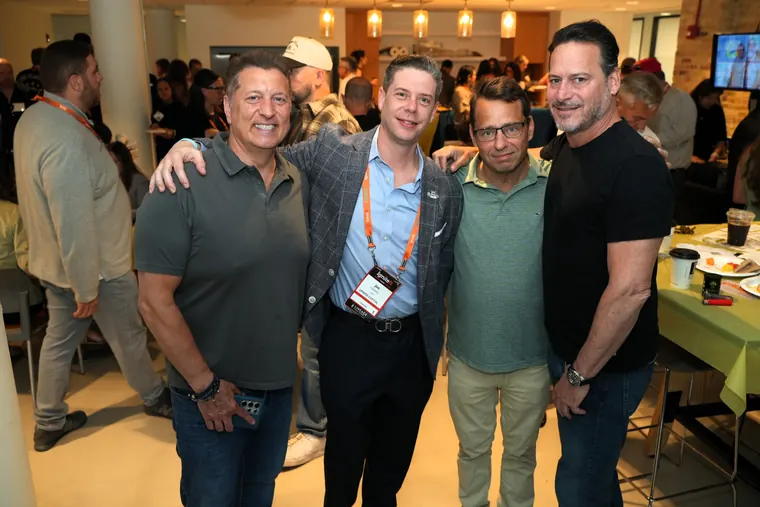 Five attendees posing arm in arm