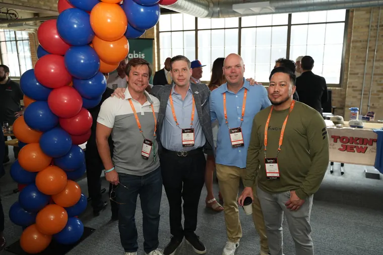 Group of attendees posing beside a balloon arch