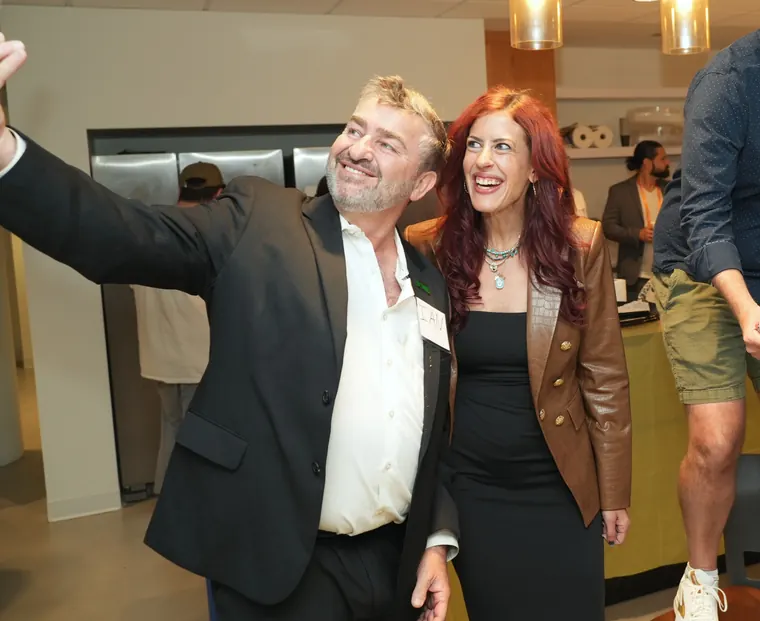Guest raising a phone for a selfie with a friend