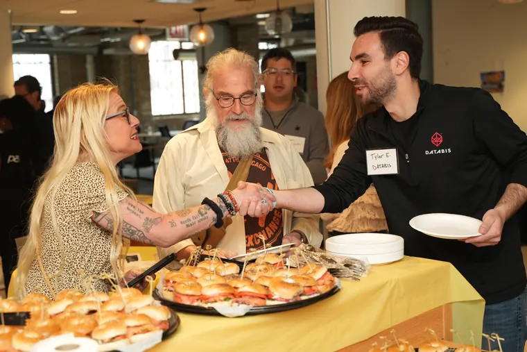 Guests shaking hands across the bagel platters