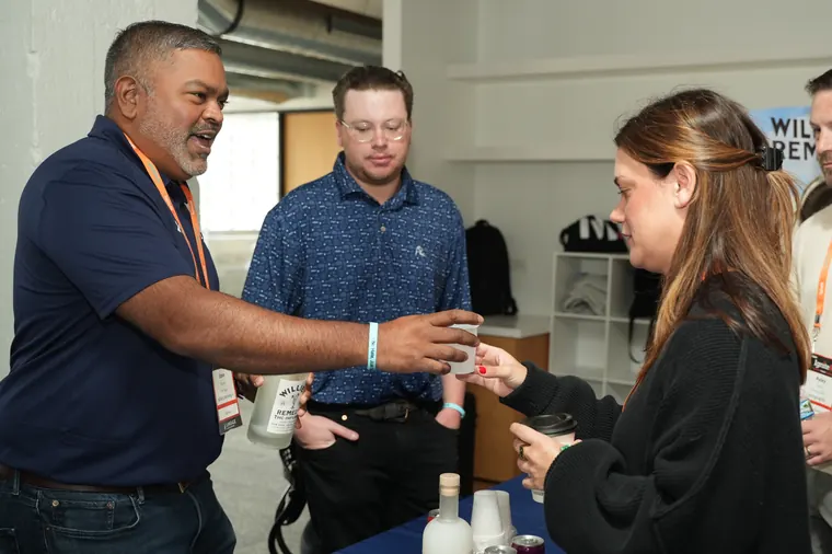Attendees chatting at an exhibitor table