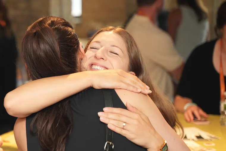 Two attendees embracing