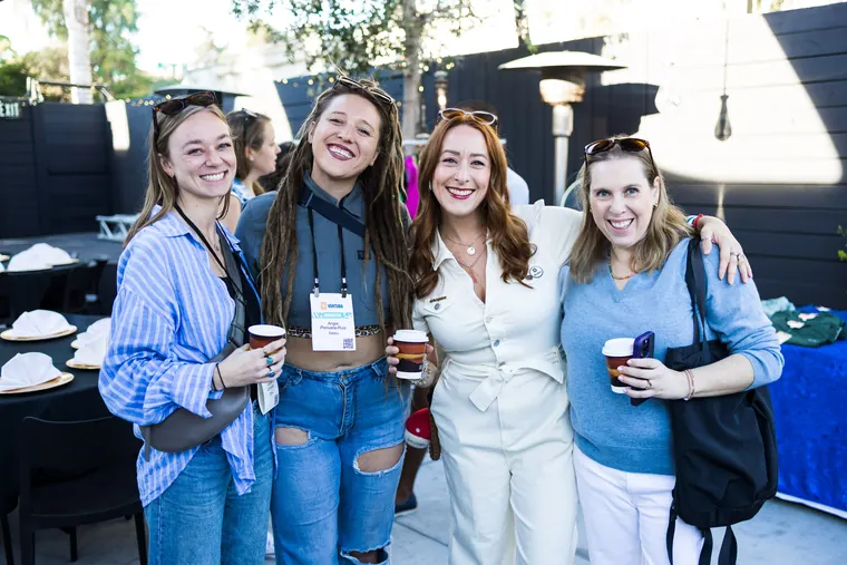 Four women posing together with coffee cups