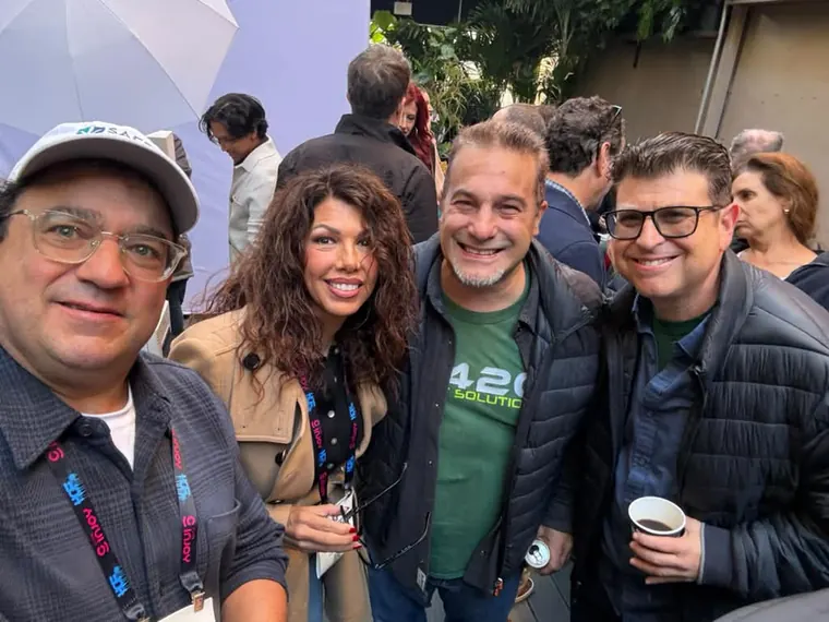Four guests squeezing into a selfie on the rooftop