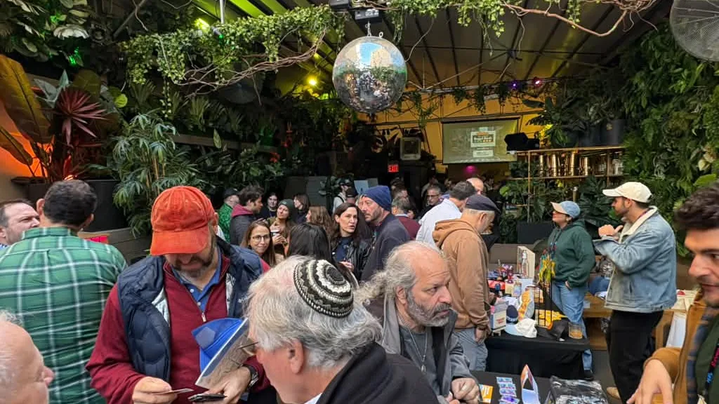 Guests crowding the vendor tables under the disco balls at The Delancey Rooftop