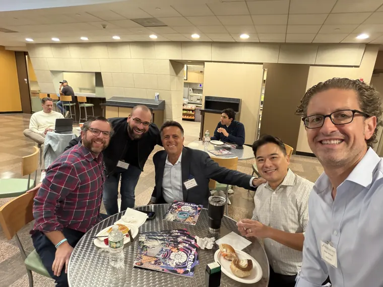 Jordan Isenstadt with guests gathered around a table with coffee and bagels
