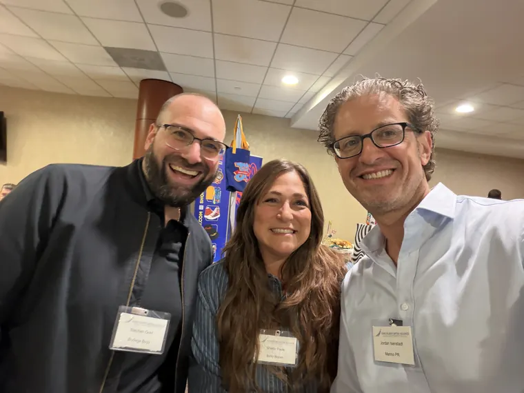 Jordan Isenstadt with two attendees wearing name tags