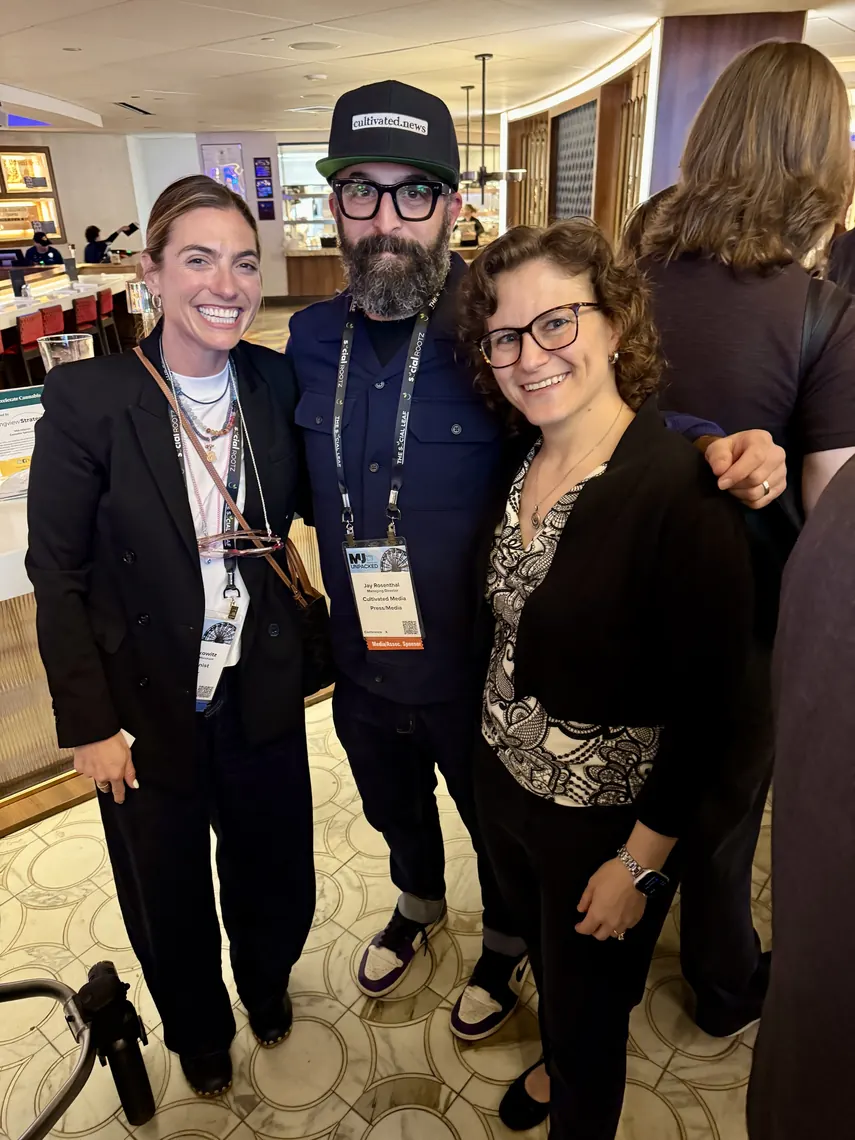 Three attendees in conference lanyards at the Center Bar