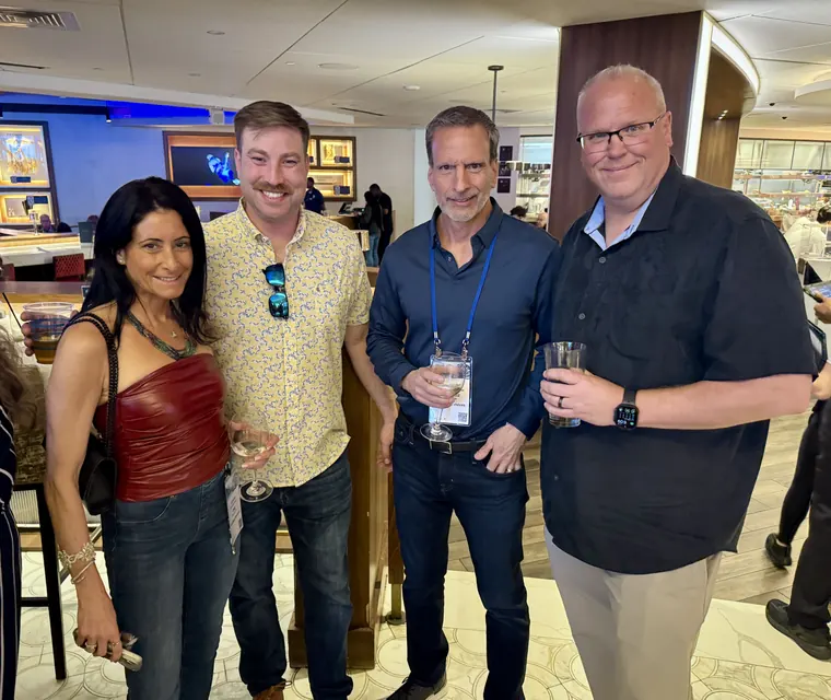 Four attendees posing together in the bar area