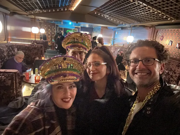 Guests in gold captain's hats and Mardi Gras beads with Jordan Isenstadt at Torches NYC