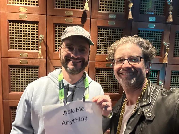 Jordan Isenstadt with a guest holding an Ask Me Anything sign