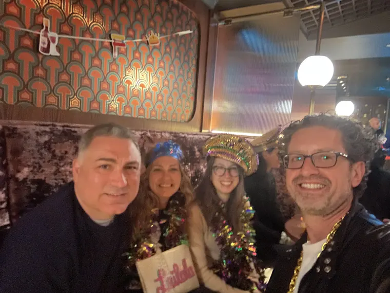 Guests in beads and sequins crowded into a booth with Jordan Isenstadt